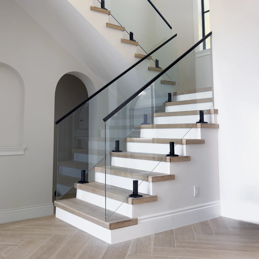 Staircase with sleek glass balustrade and wooden steps.