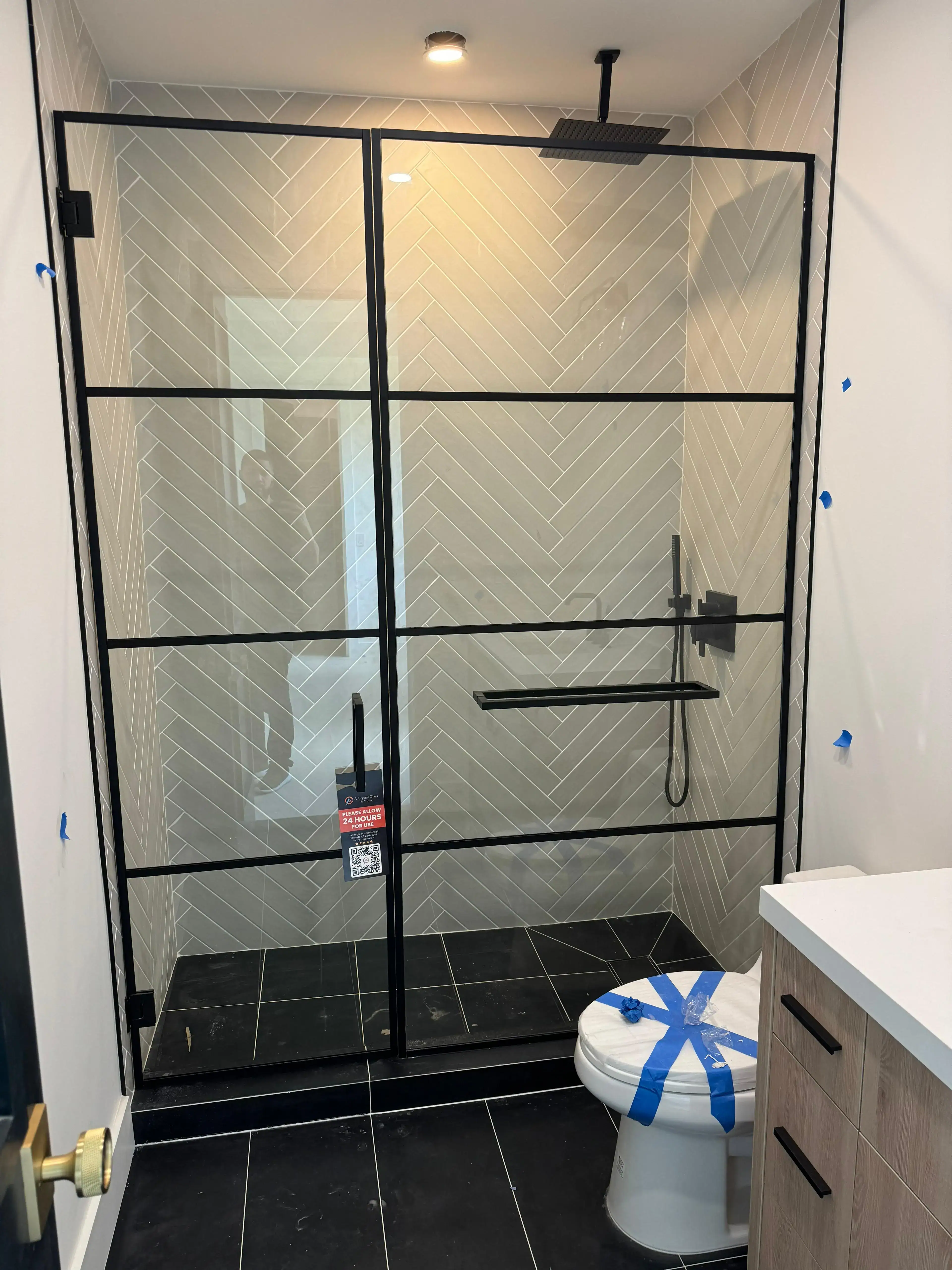 Stylish black-framed glass shower enclosure with modern tile walls. Perfect for contemporary bathrooms.