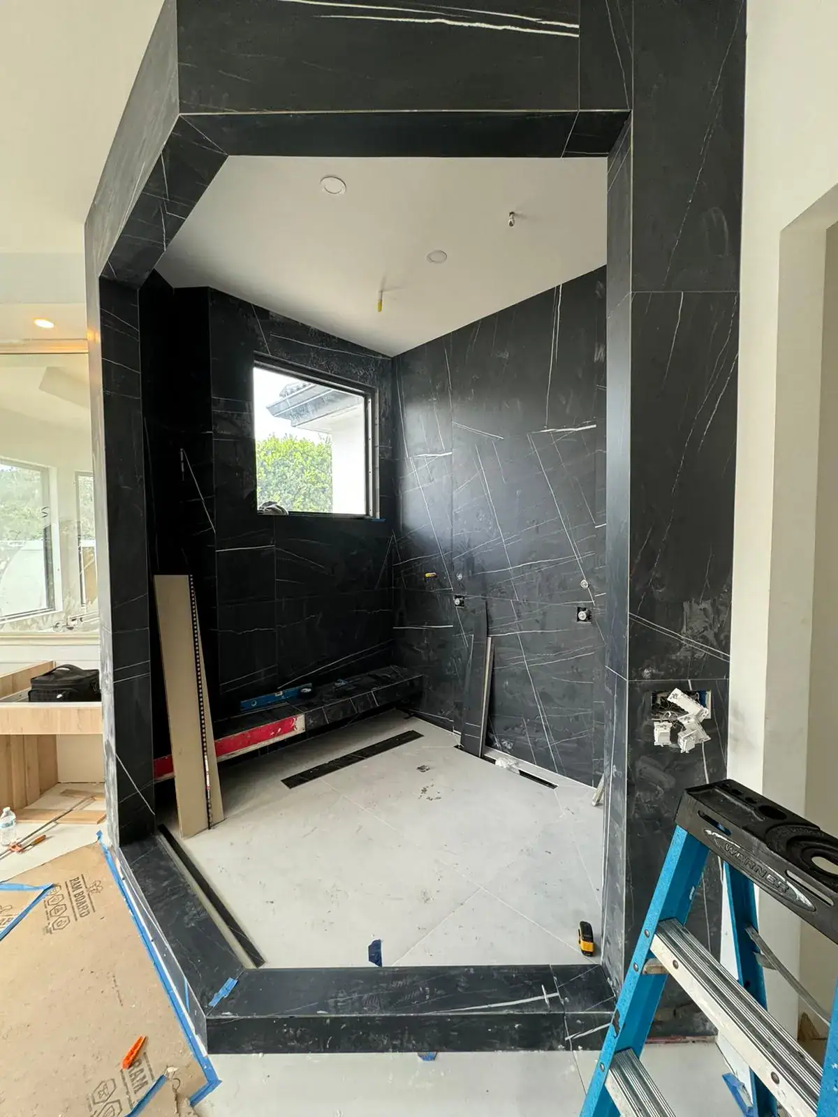 High-quality black marble mirror and glass installation in modern bathroom.