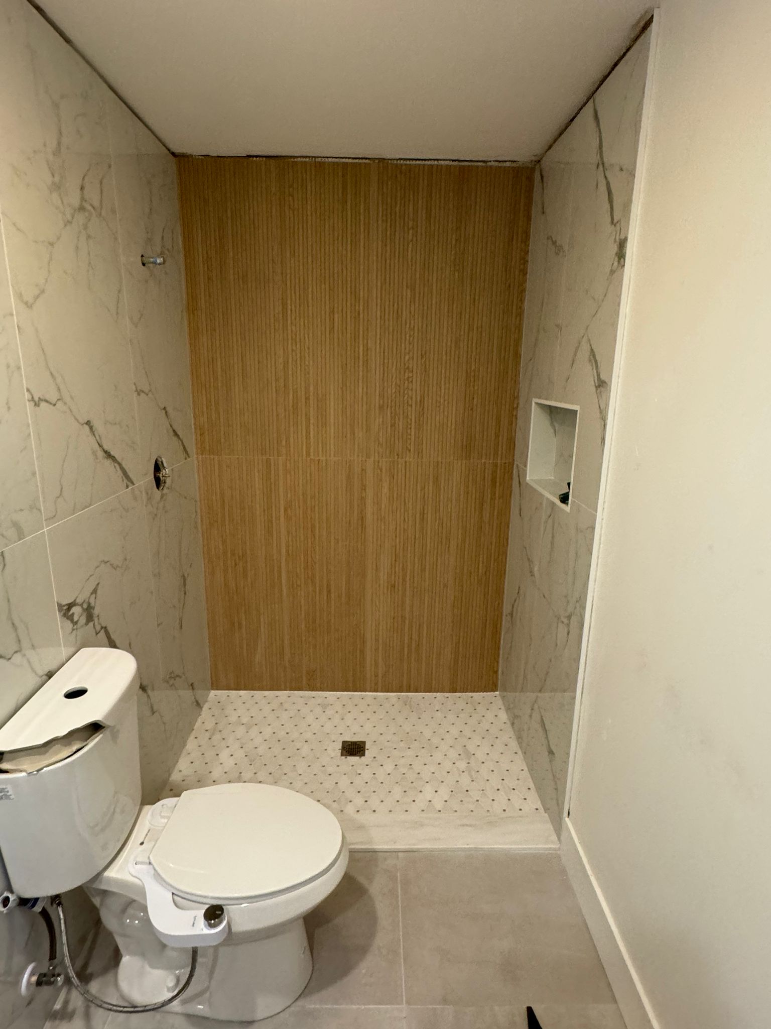 High-quality glass and mirror installation in modern bathroom with marble and wood finishes.