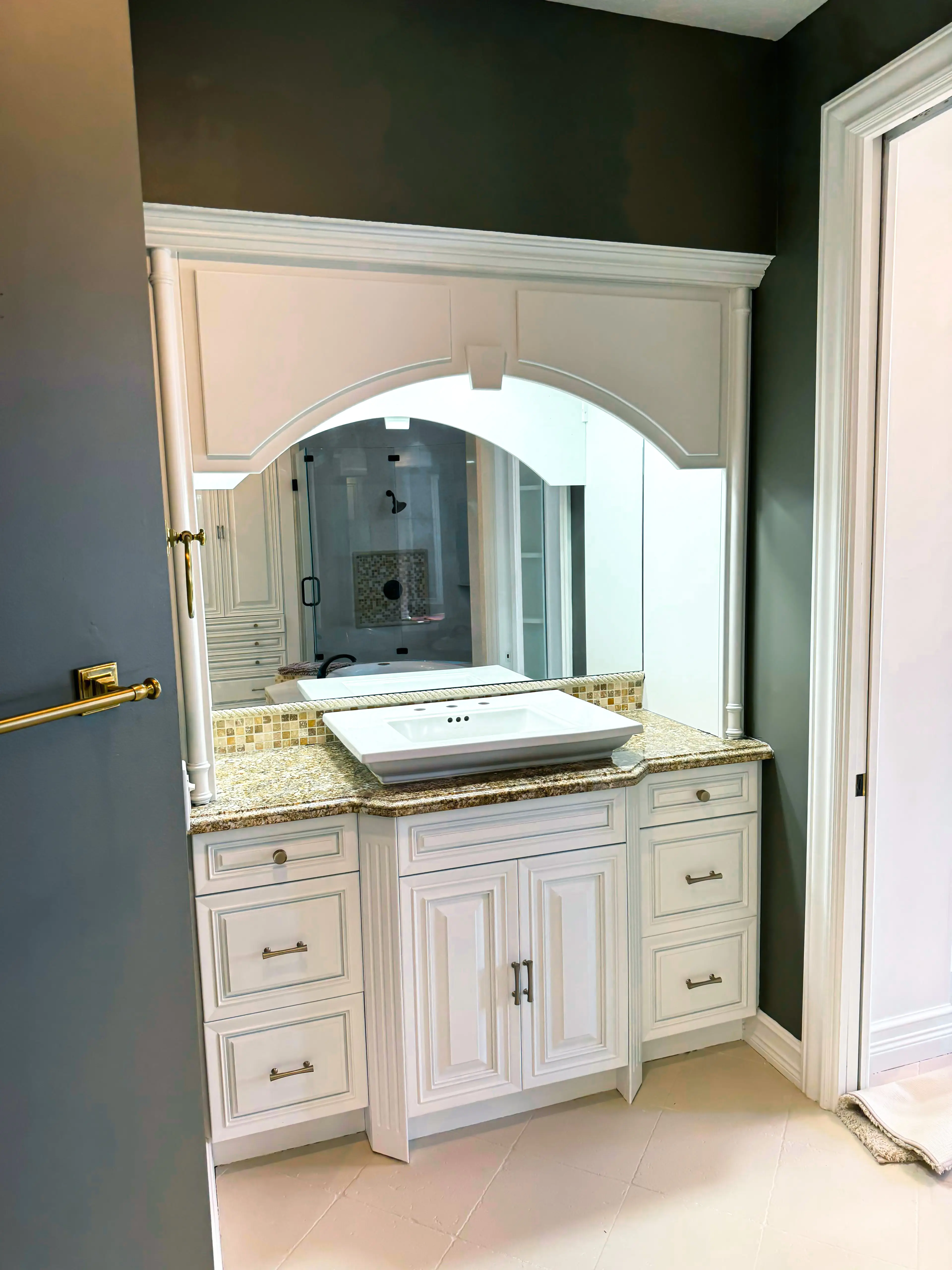 Mirror with decorative glass andwood frame enhances bathroom decor.