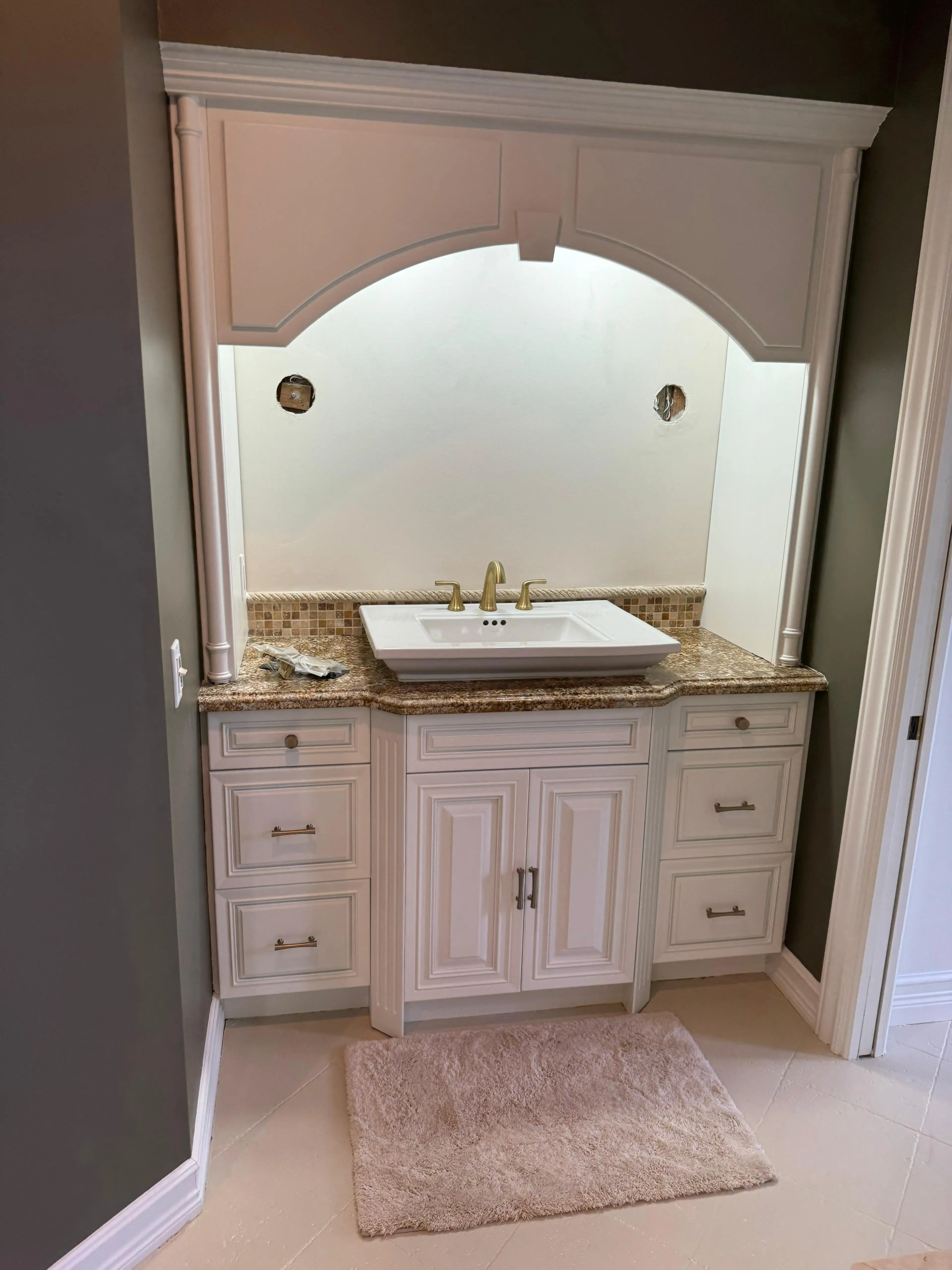 Custom glass mirror over vanity with decorative frame.