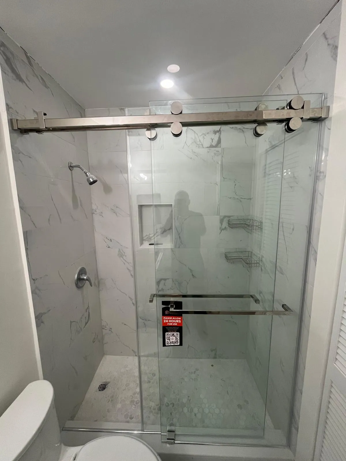 Modern glass shower enclosure with stainless steel hardware.