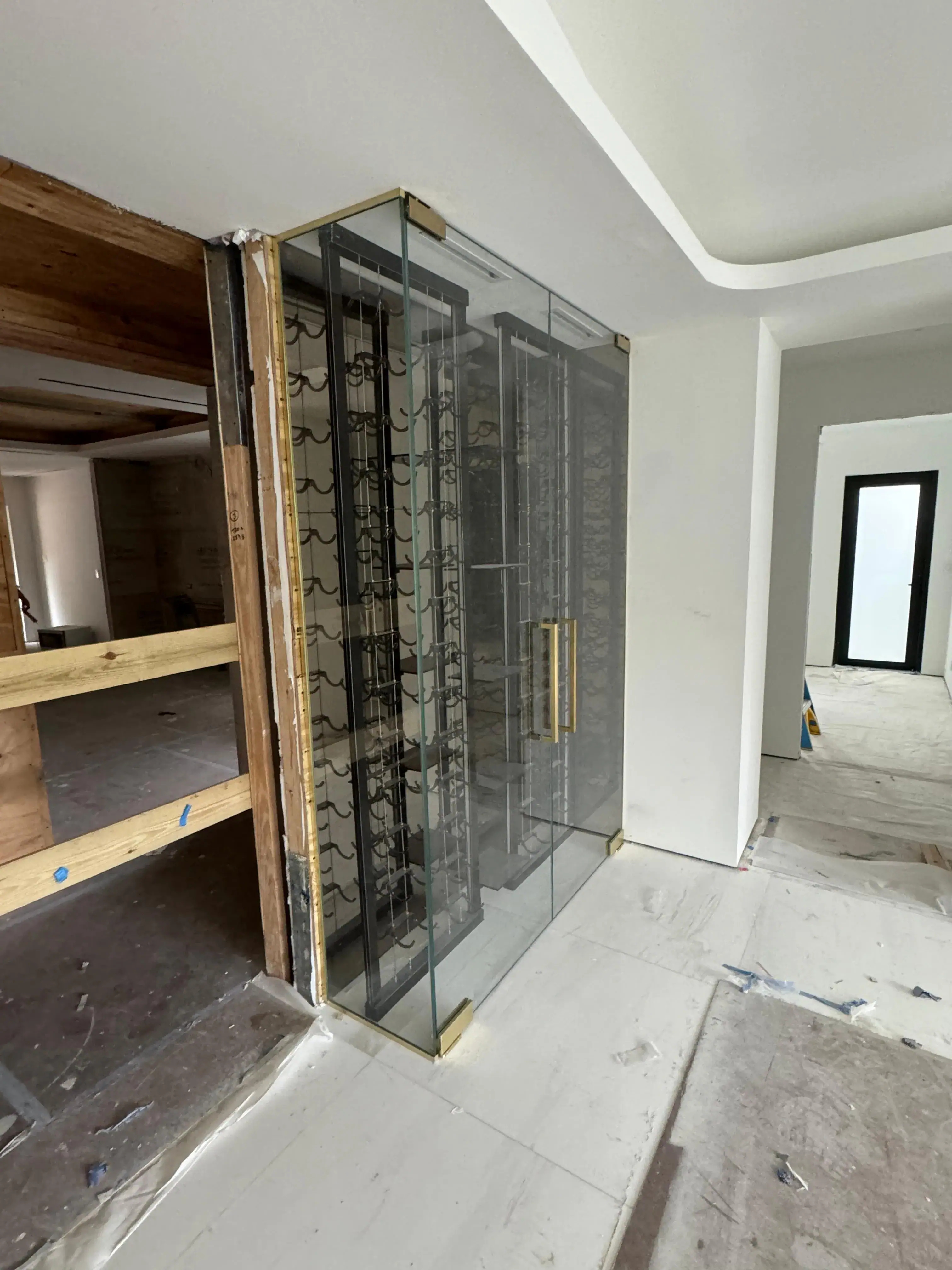 High-quality glass wine cellar door with gold accents and sleek design.