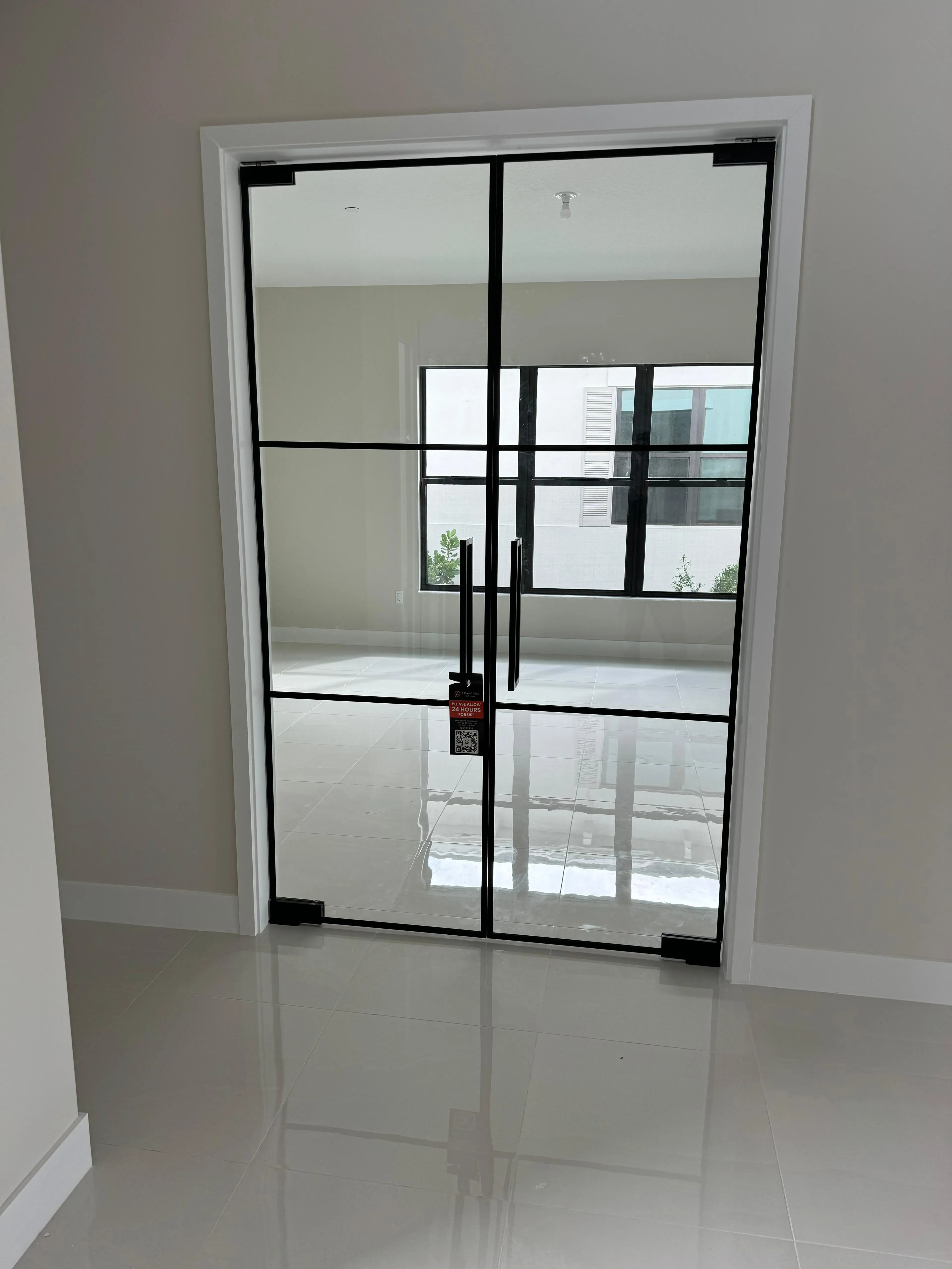 High-quality glass door with black metal framing, suitable for modern interiors, featuring sleek mirror-like finish.