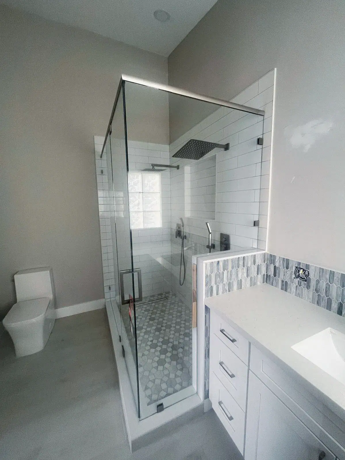 High-quality glass shower with modern fixtures and stylish tile design in a contemporary bathroom.