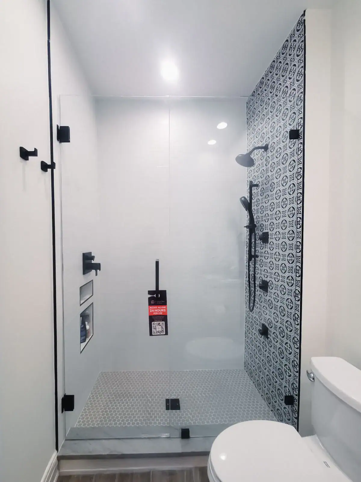 Clear glass shower door and stylish patterned tiles in a bathroom setting.