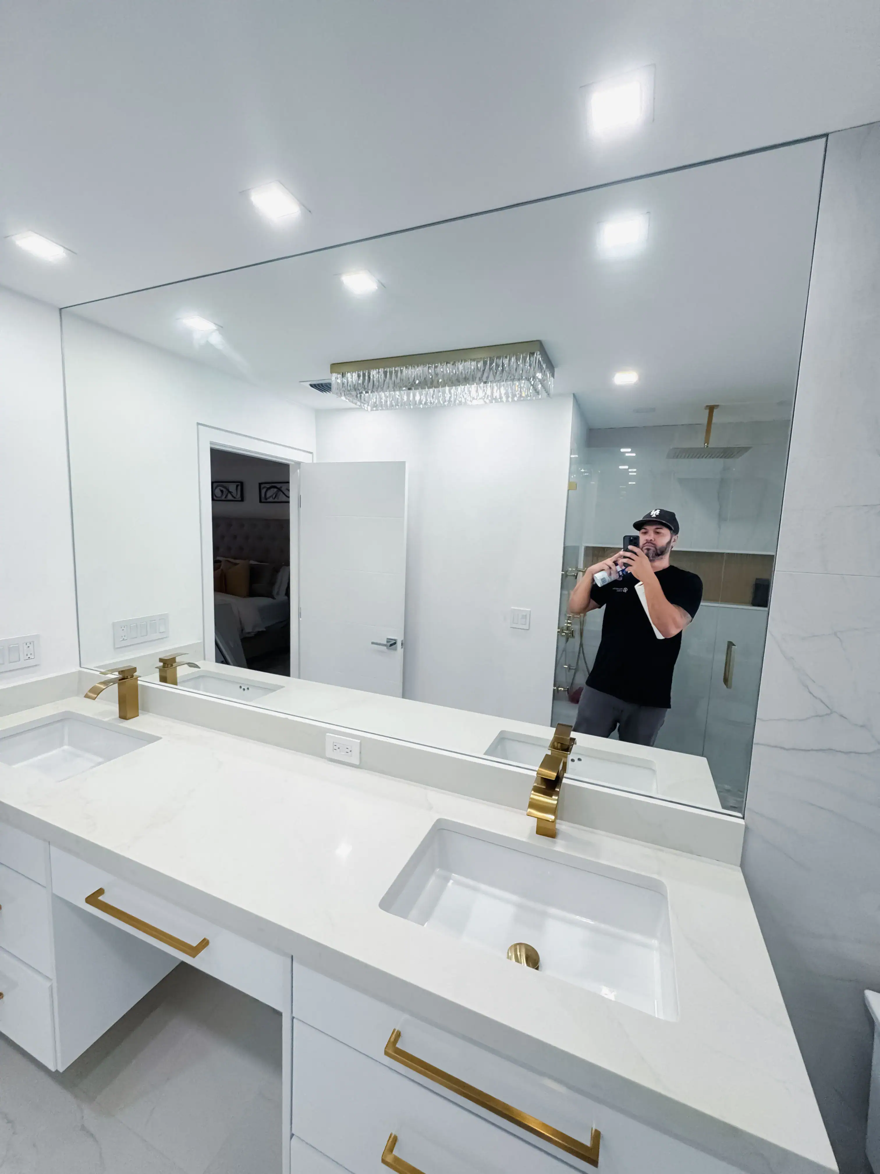Mirror, glass bathroom countertop, gold fixtures, modern home renovation, luxury bathroom design.