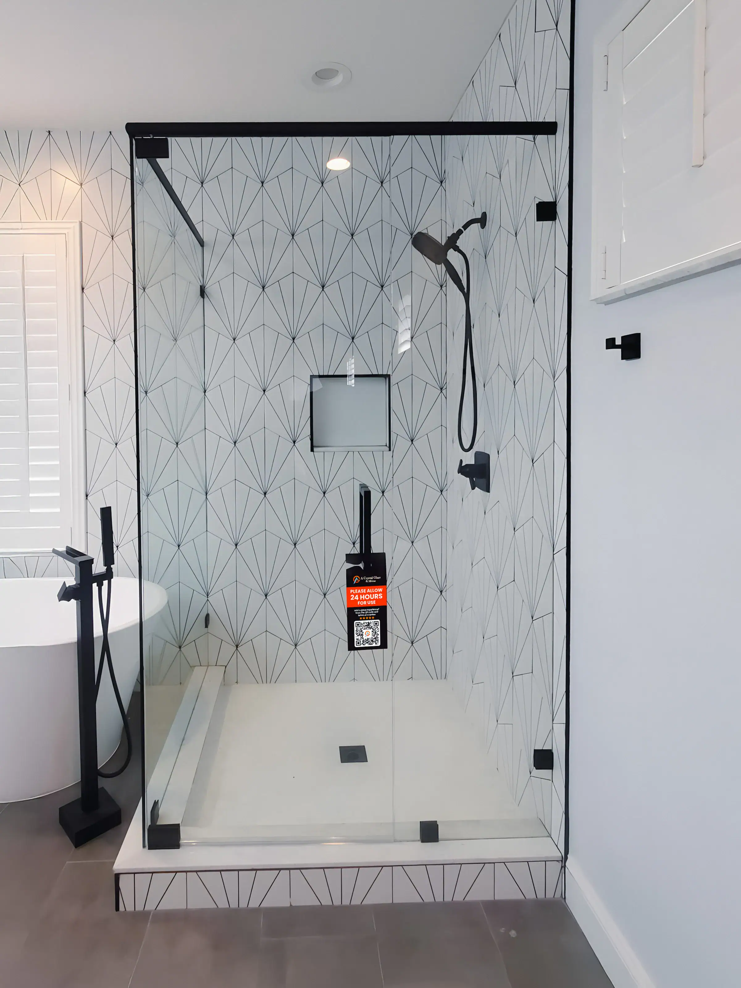 Beautiful modern glass shower with black hardware and geometric tiles, perfect for luxury bathrooms.