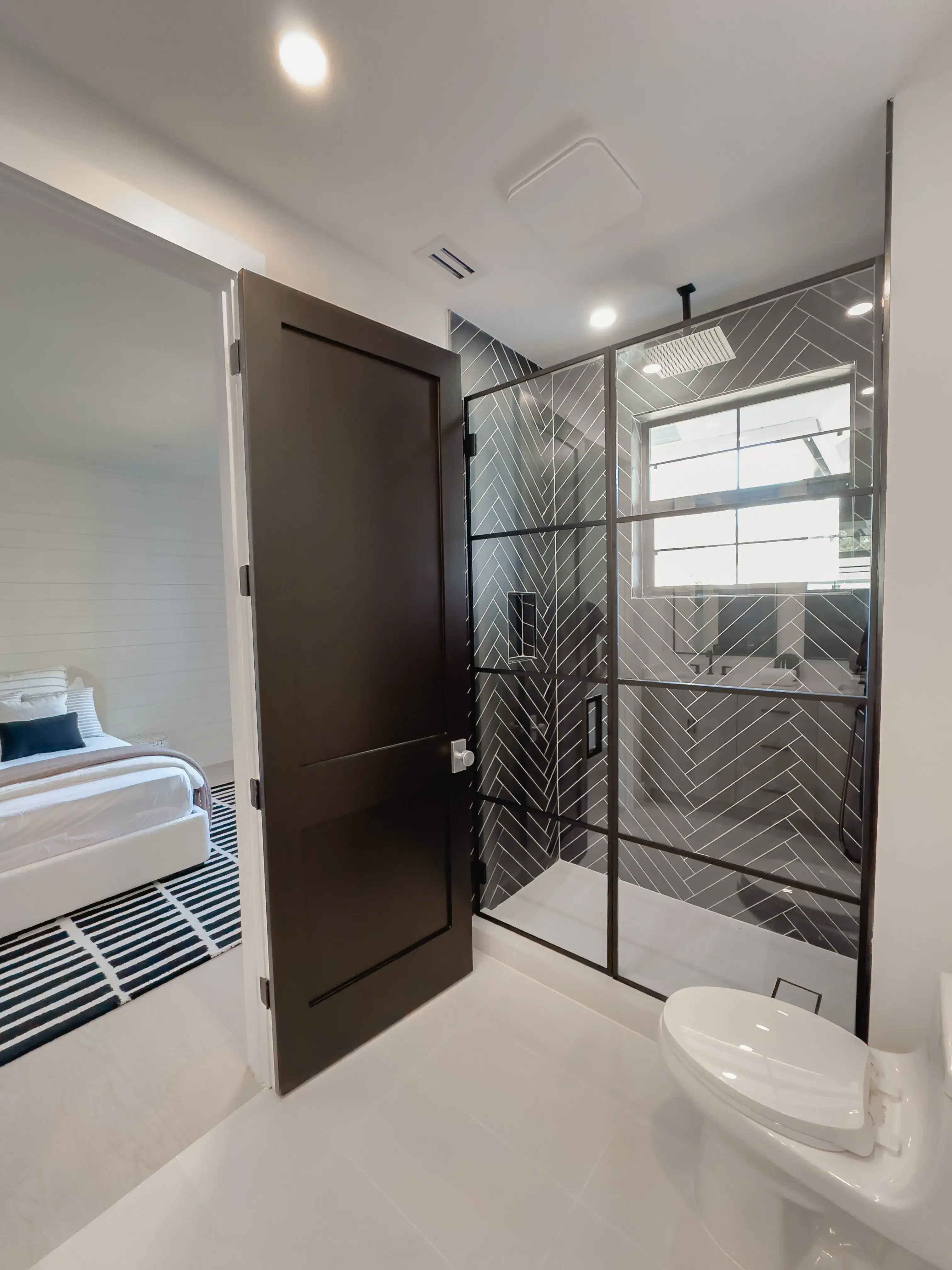High-quality glass shower door with black frame, modern tile design, and window for natural light.