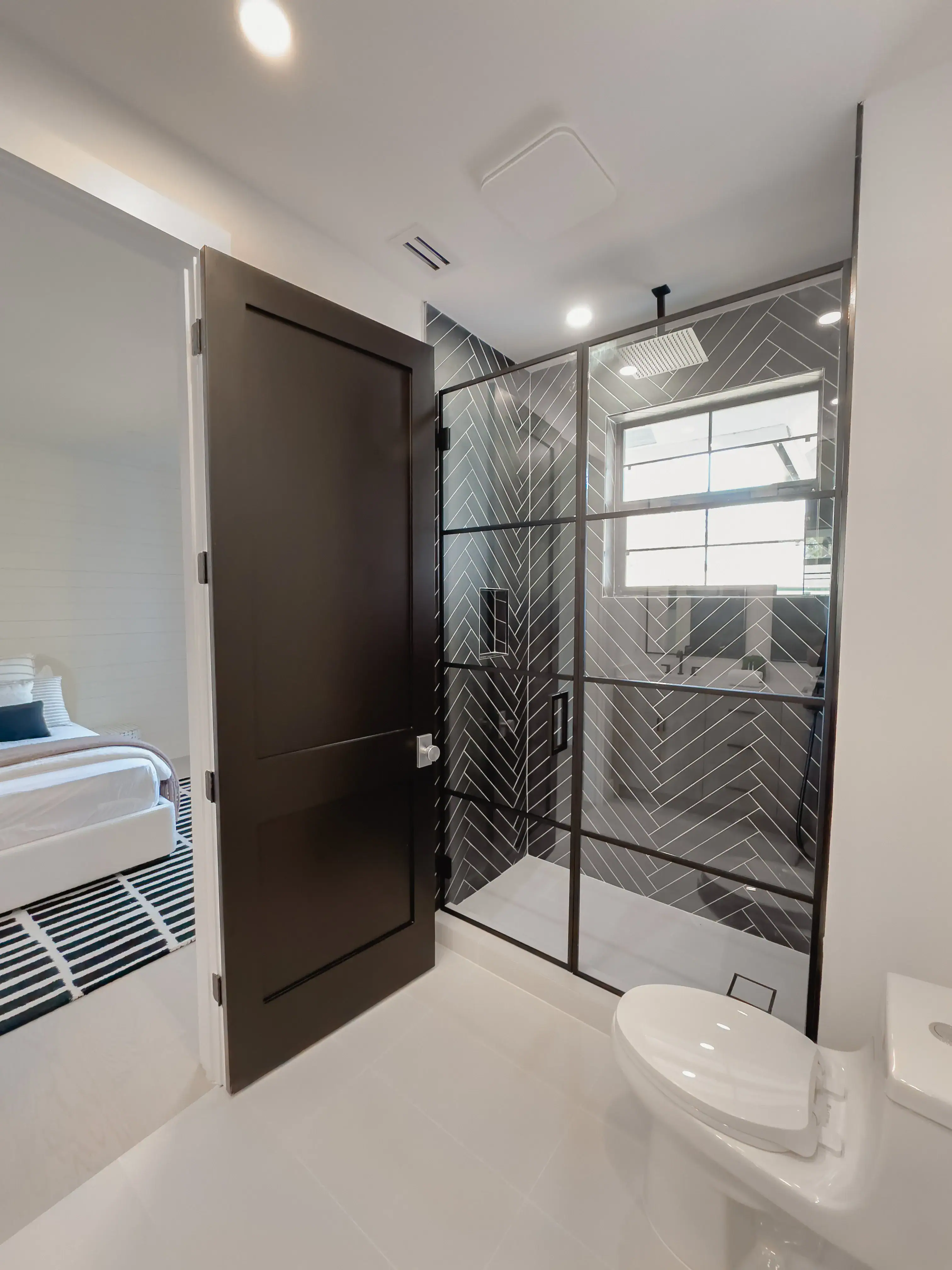 Durable glass shower with black metal frame complements contemporary bathroom style.