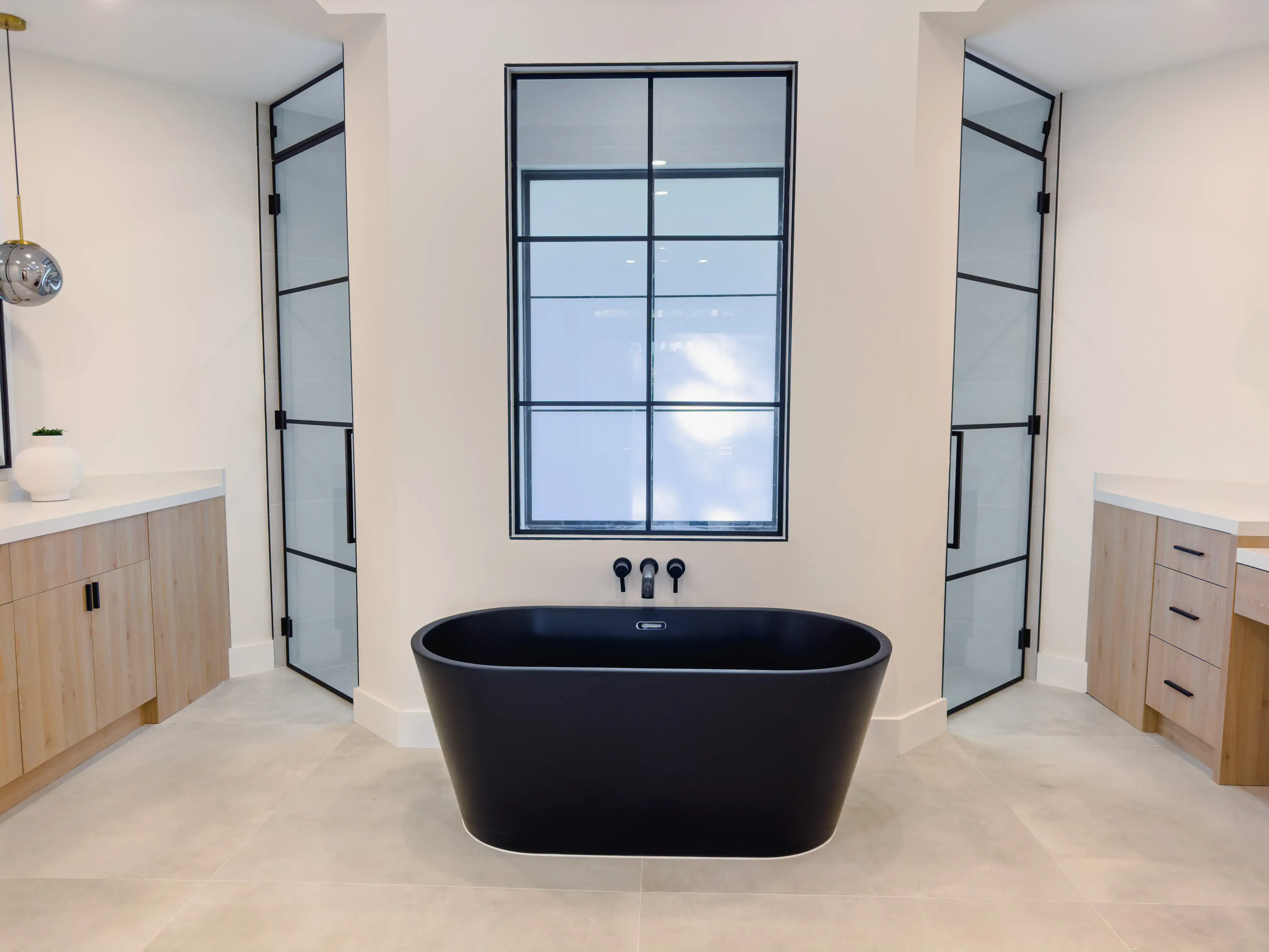 High-quality black freestanding bathtub with clawfoot design in a sleek, modern bathroom setting.
