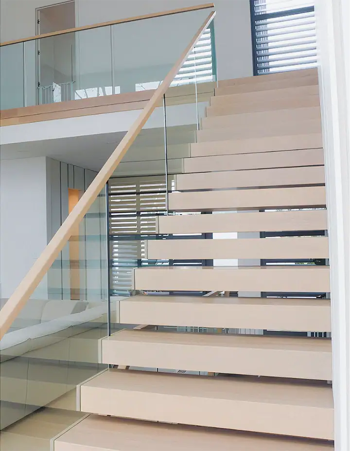 Beautiful glass and wood staircase with modern design and safety features.