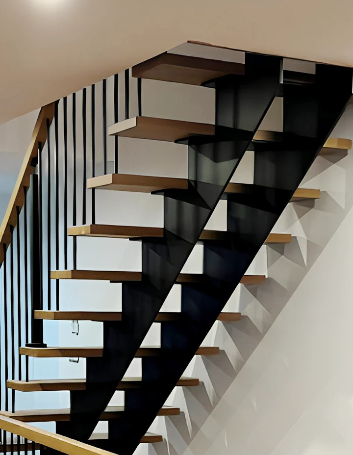 Stunning modern staircase featuring floating wooden steps with glass railing and black metal supports.