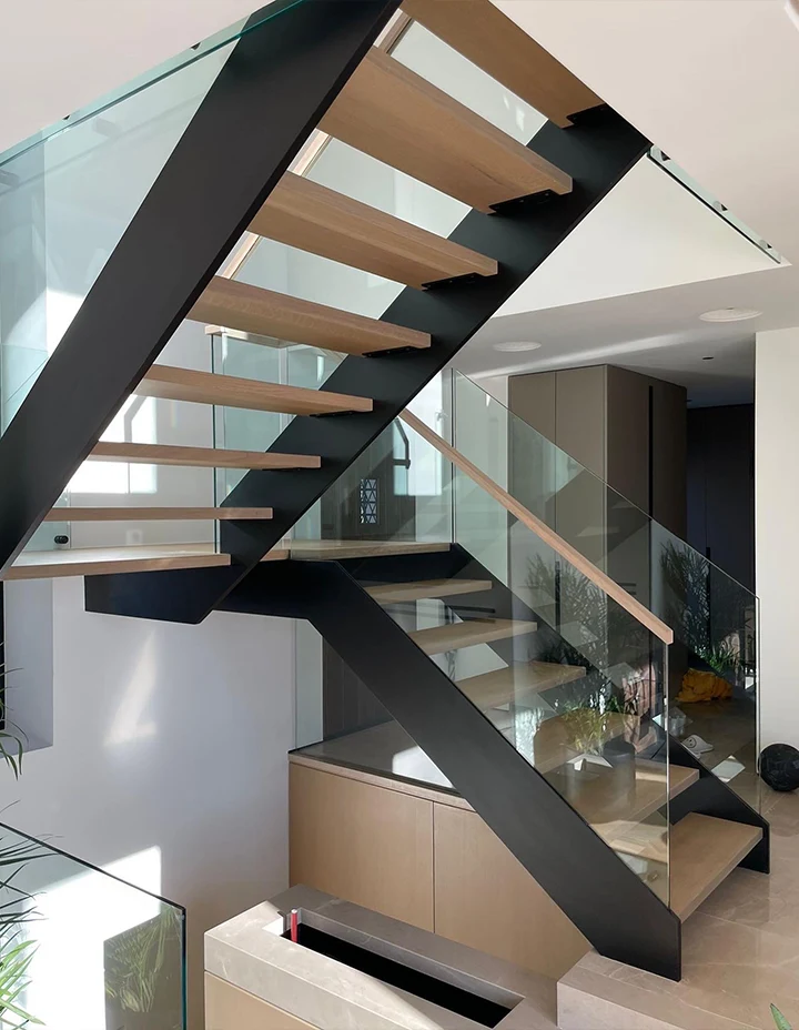 Stunning glass and wood staircase with sleek black metal support, ideal for contemporary interiors.