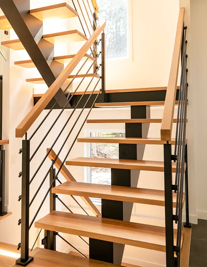 Elegant crystal glass and mirror staircase with modern black metal accents for stylish interior design.