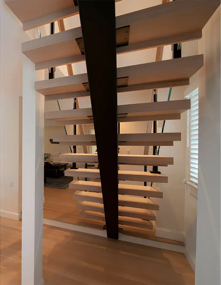 Elegant glass and wood floating staircase in contemporary home interior.