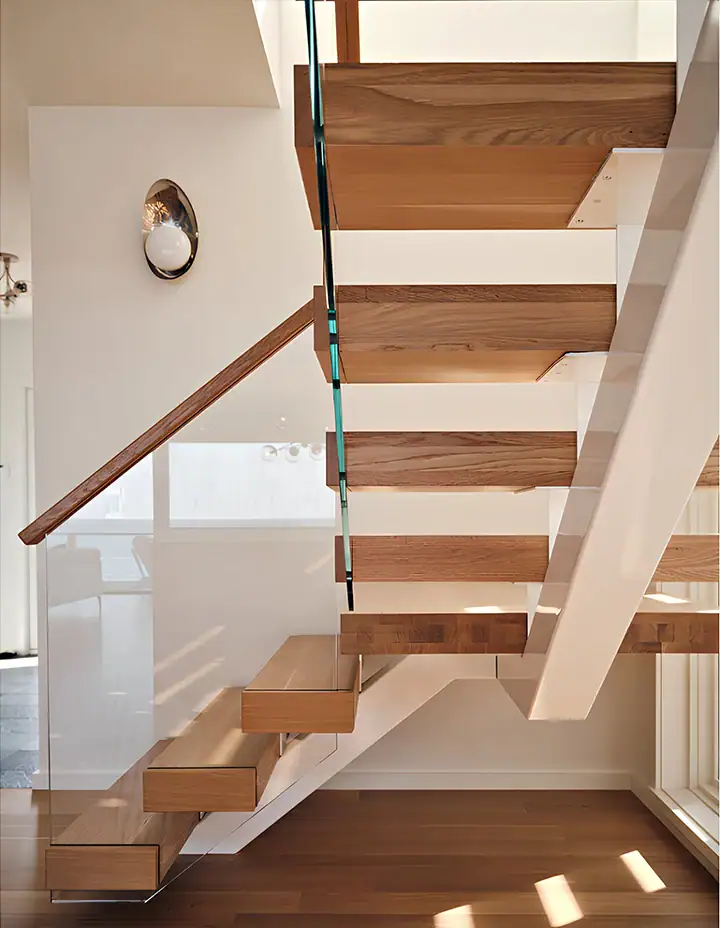 Elegant staircase with glass balustrades and wooden steps, enhancing contemporary home interior design.
