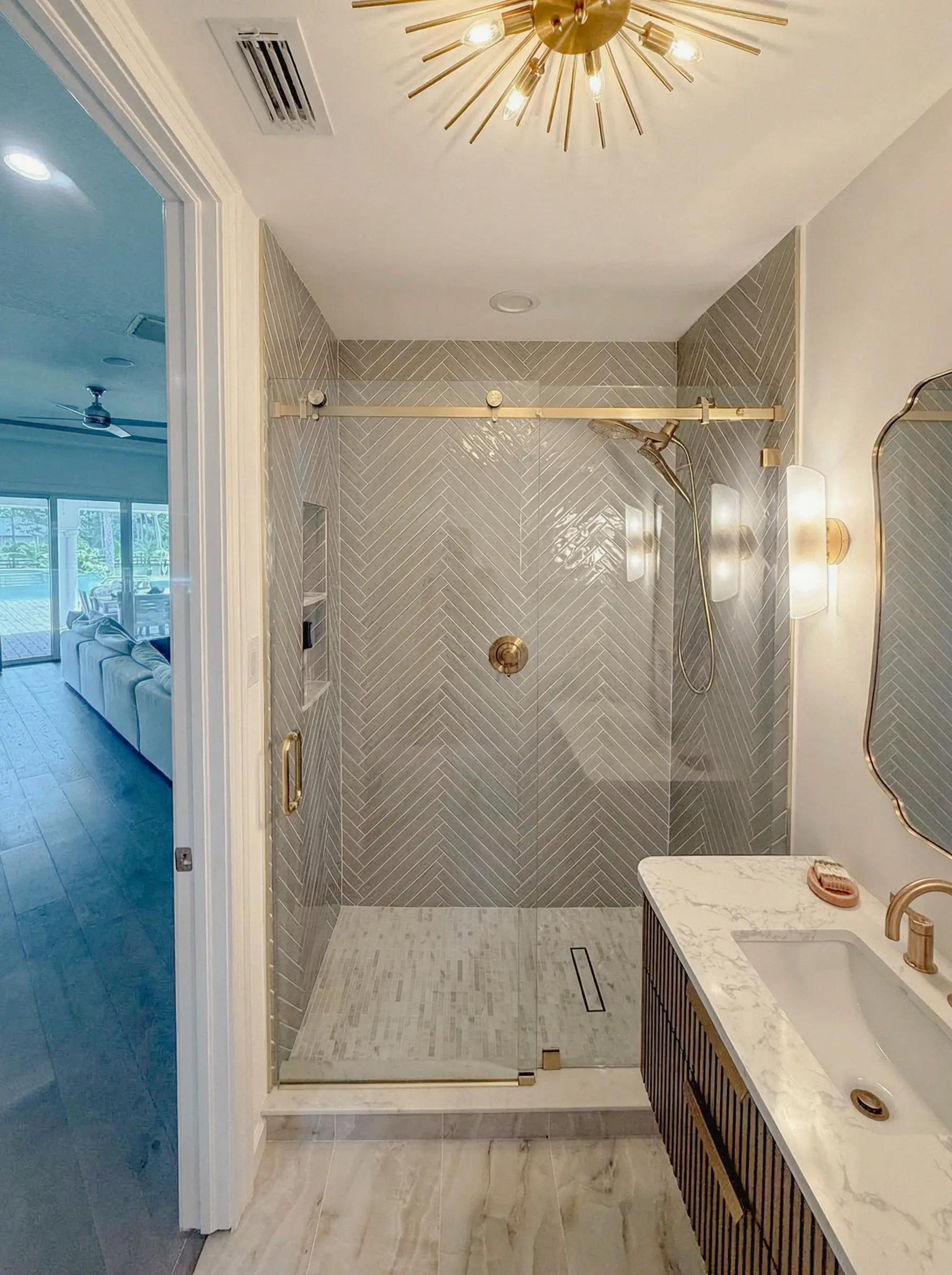 Bright bathroom featuring custom glass mirror and marble vanity.