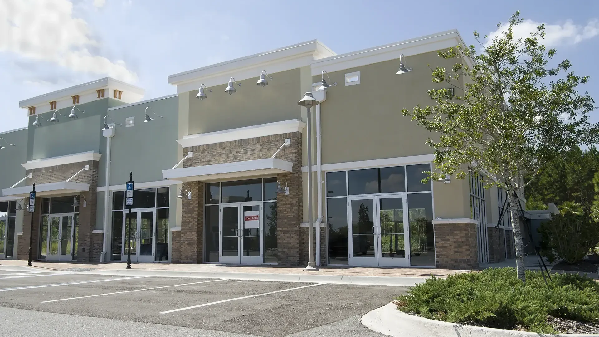 Bright commercial building showcasing glass doors, windows, and decorative glass elements for retail or office use.