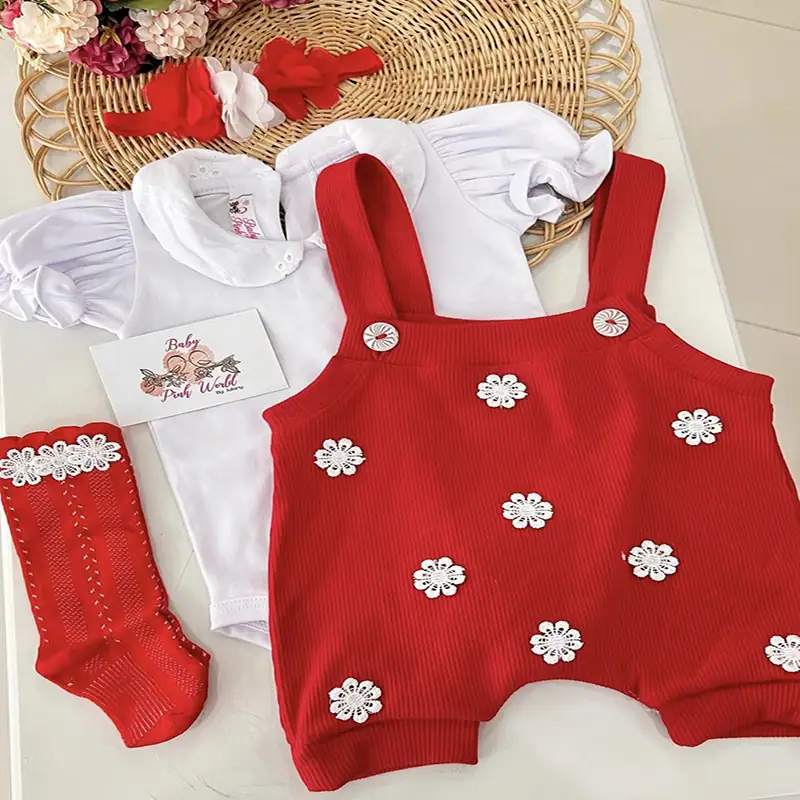 Ropa de bebé niña blanca con peto rojo decorado con flores, perfecta para ocasiones especiales.